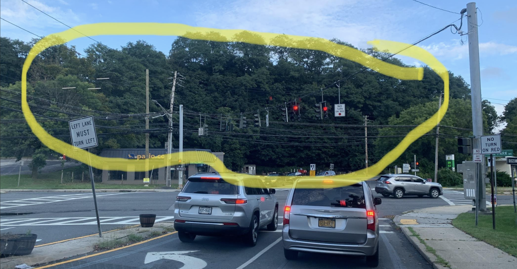 View from the Central Avenue and Underhill Road intersection toward the wooded hillside, which is circled in yellow.
